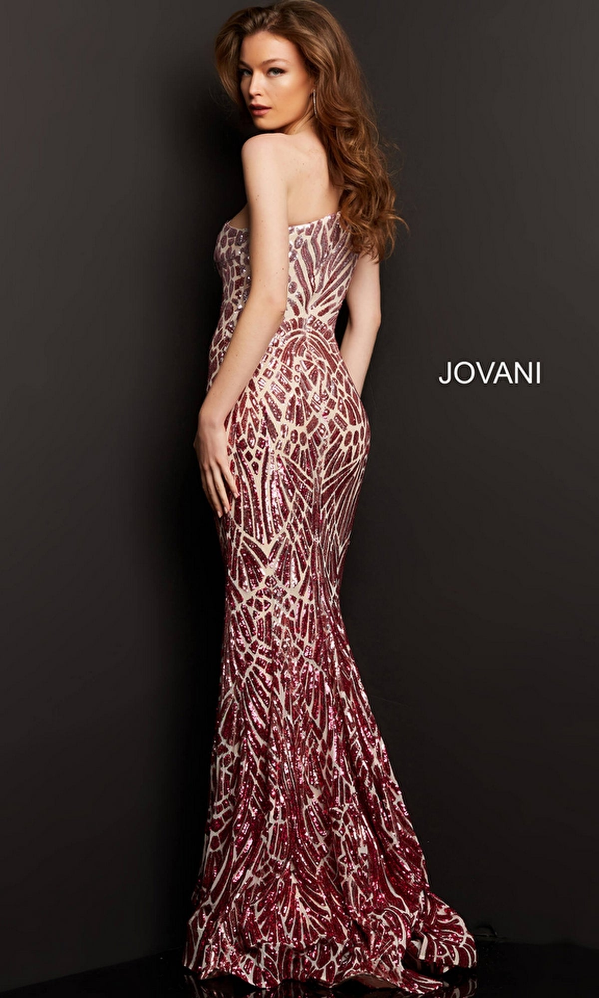 A woman wearing the Jovani 06469 Ombre Sequin-Print Prom Gown stands against a black background. The dress features a strapless, floor-length, form-fitting silhouette with an ombre sequin design.